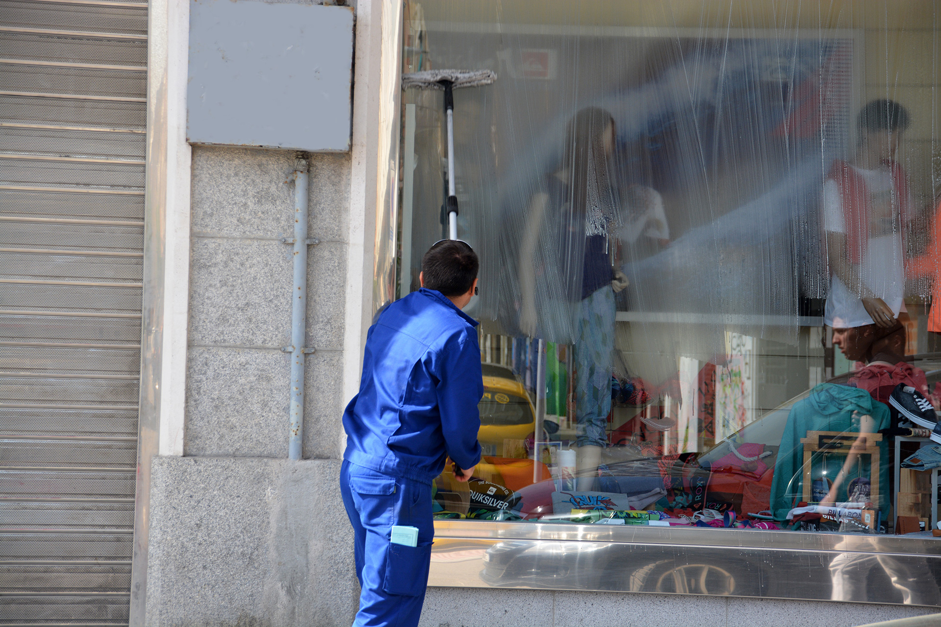 Window cleaner cleaning shop window