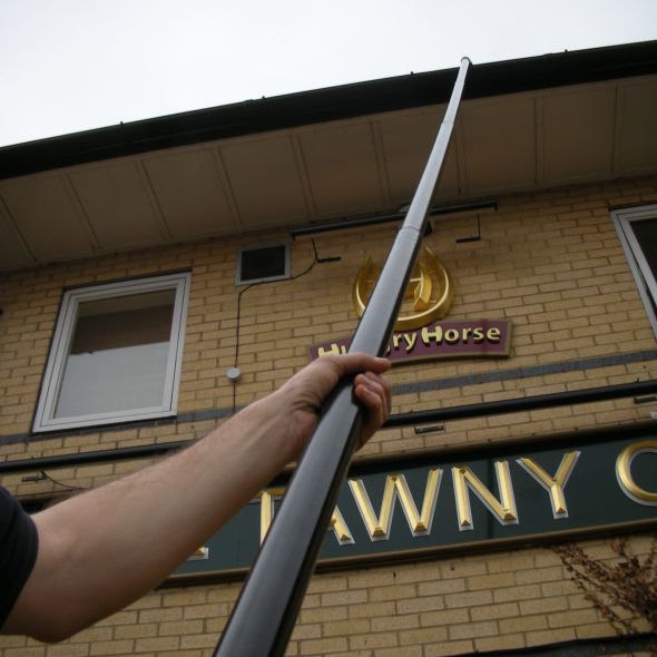 cleaning a gutter at a pub