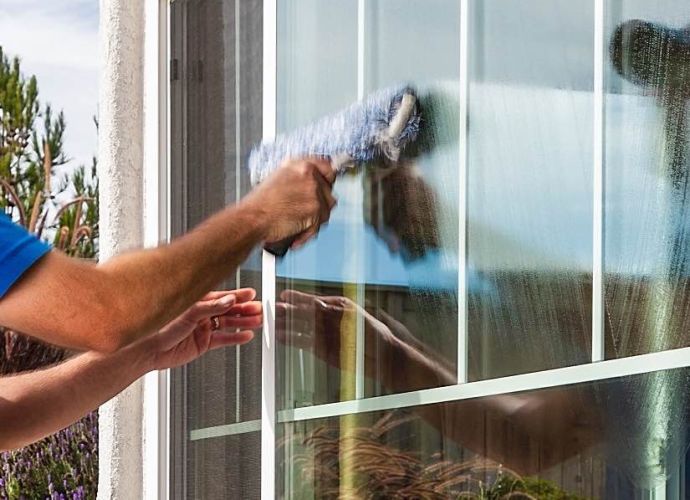 man washing the front of a window