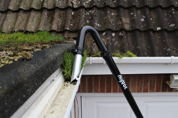 vacuum cleaning moss from a roof gutter