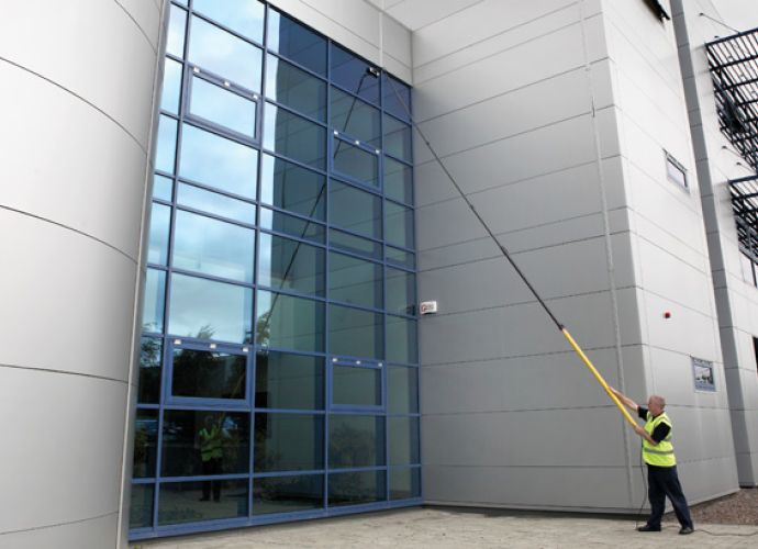 man cleaning the front of a building